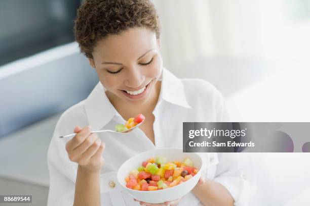 woman eating fruit salad - fruit salad stock pictures, royalty-free photos & images