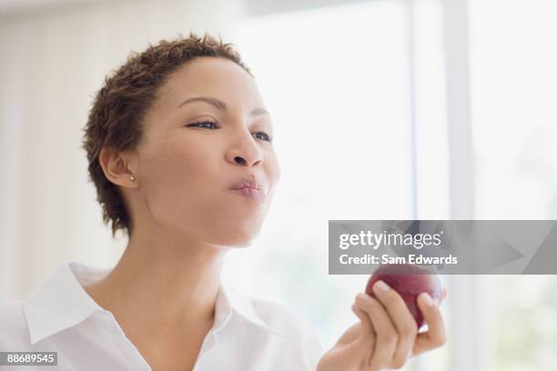 mujer comiendo manzana - masticar fotografías e imágenes de stock