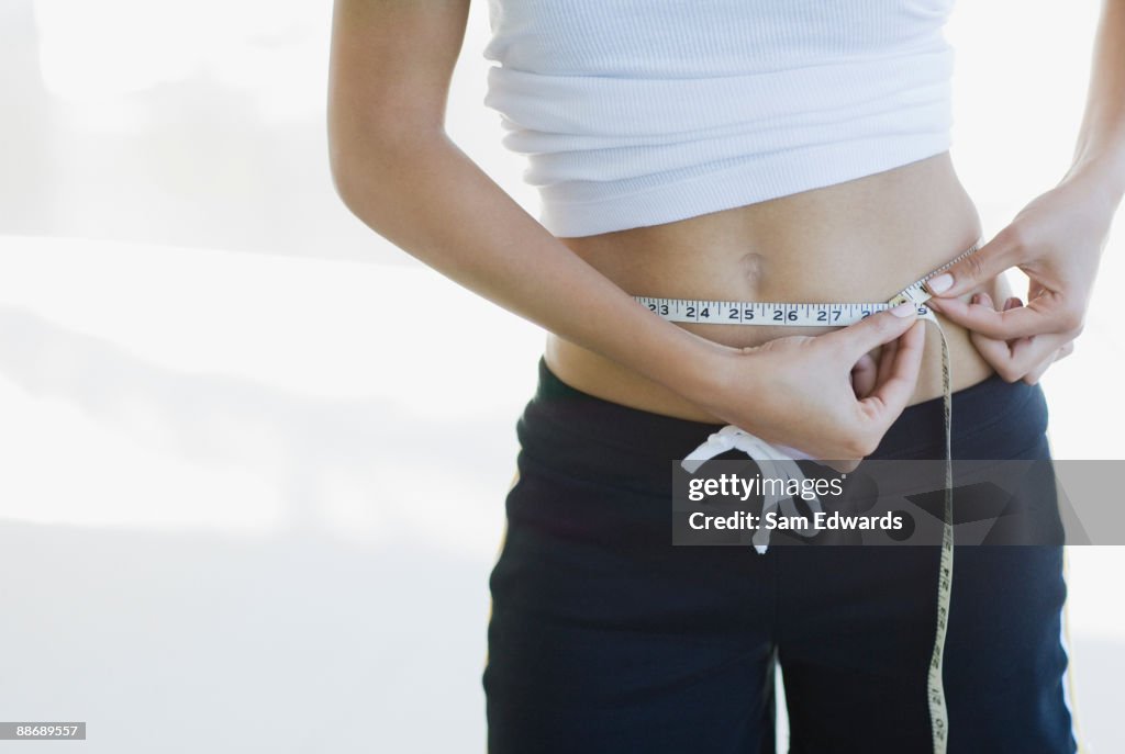 Woman measuring waistline