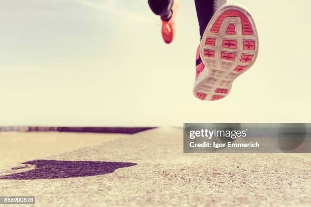 young man running outdoors, mid air, low section - feet moving stock-fotos und bilder