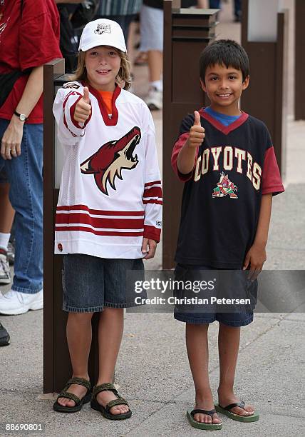 Fans of the Phoenix Coyotes give the thumbs up as they wait in line outside of Jobing.com Arena during an open house on June 25, 2009 in Glendale,...