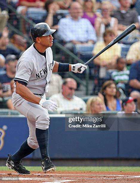 Third baseman Alex Rodriguez of the New York Yankees follows through and watches his home run in the first inning during the game against the Atlanta...