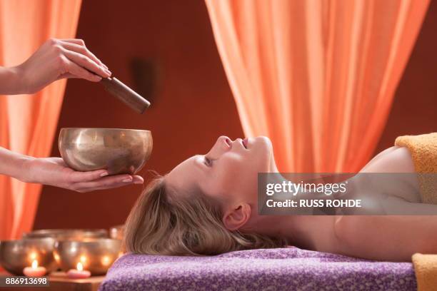 woman in spa environment, having relaxation treatment, therapist holding tibetan bowl - rin gong 個照片及圖片檔