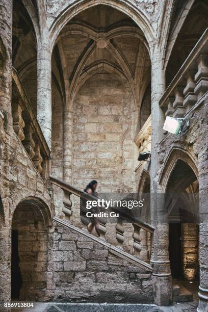 female tourist and baby moving down church stairway, pezenas, occitanie region, france - pezenas fotografías e imágenes de stock