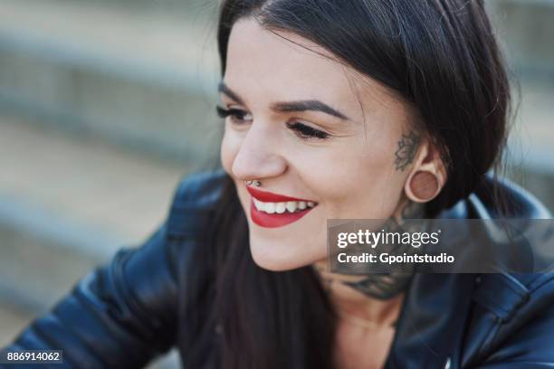 portrait of young woman smiling, tattoos on neck, nose and ear piercings, close-up - pierced stock pictures, royalty-free photos & images