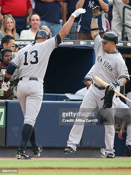 Nick Swisher of the New York Yankees congratulates teammate Alex Rodriguez after Rodriguez's first inning home run during the game against the...
