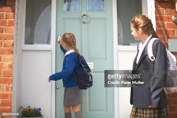 school girl and teenage sister closing front door - school closing stock pictures, royalty-free photos & images