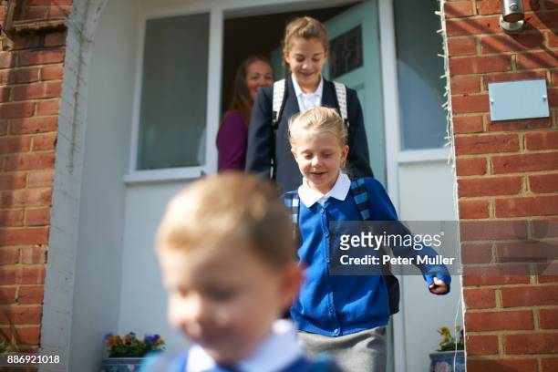 school boy and sisters leaving front door - parent daughter school uniform stock pictures, royalty-free photos & images