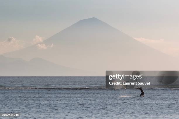 a fisherman casting a net, gili trawangan, indonesia - laurent sauvel stock pictures, royalty-free photos & images