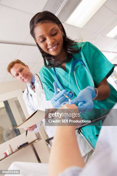 profesional de la salud administración de fármacos a través del suero del paciente - iv drip womans hand fotografías e imágenes de stock