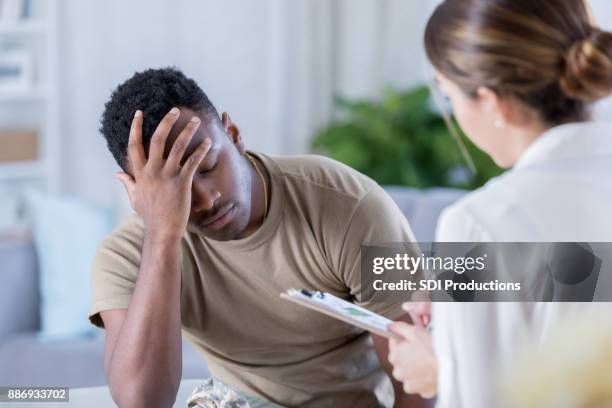 upset soldier talks with therapist - vulnerability stock pictures, royalty-free photos & images