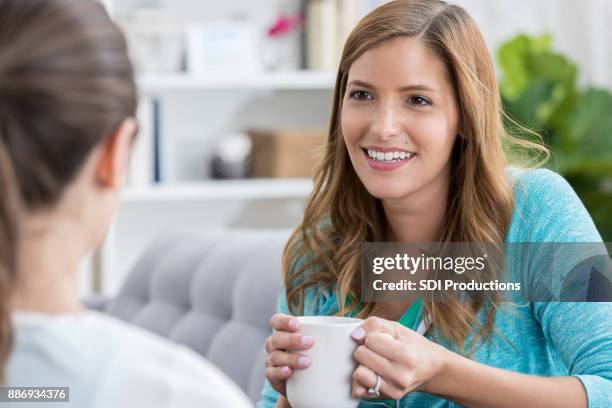 frauen genießen im chat über kaffee - family on couch with mugs stock-fotos und bilder