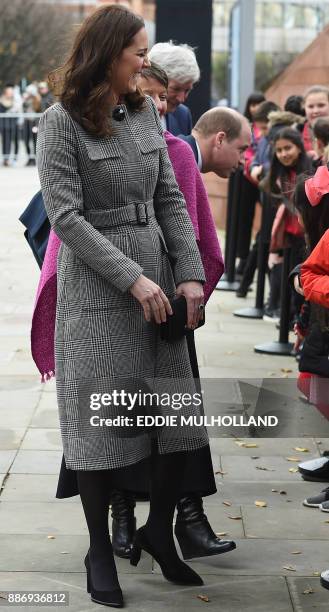 Britain's Catherine, Duchess of Cambridge and her husband Britain's Prince William, Duke of Cambridge meet children as they arrive to attend the...