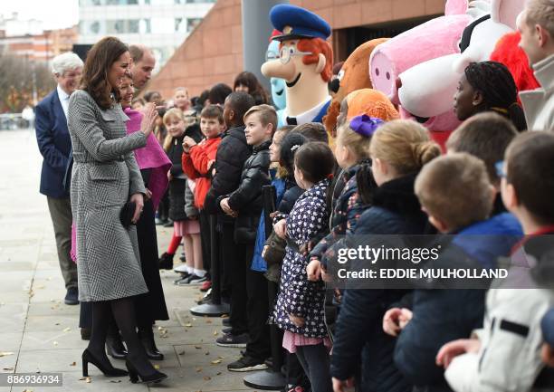 Britain's Catherine, Duchess of Cambridge and her husband Britain's Prince William, Duke of Cambridge meet children as they arrive to attend the...