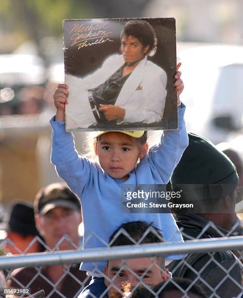 Small unidentifed young fan holds up Michael Jackson's album "Thriller" in support during his indictment on charges related to child molestation at...