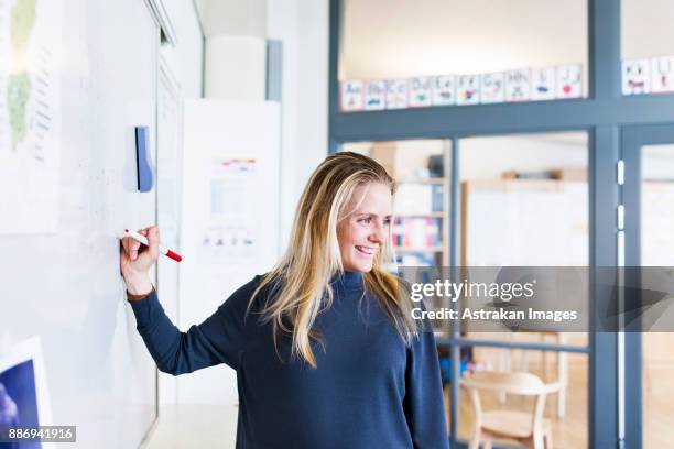 teacher writing on whiteboard - elementary school classroom stock pictures, royalty-free photos & images