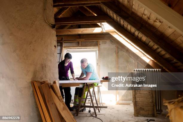 couple making plans to renovate old attic - diy house stock pictures, royalty-free photos & images