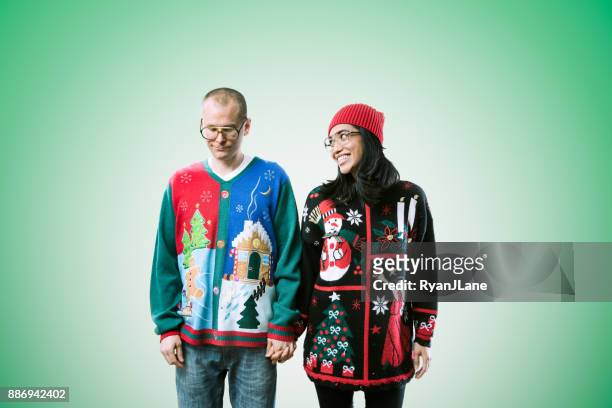 casal de camisola de natal - ugly christmas sweater party - fotografias e filmes do acervo