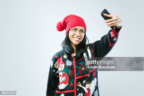 christmas sweater woman taking selfie - feio imagens e fotografias de stock