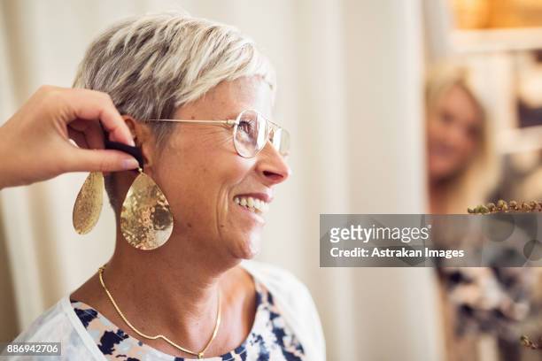 woman trying earrings - earring stock pictures, royalty-free photos & images