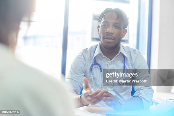 male doctor giving diagnosis to patient - doctor giving good news stock pictures, royalty-free photos & images