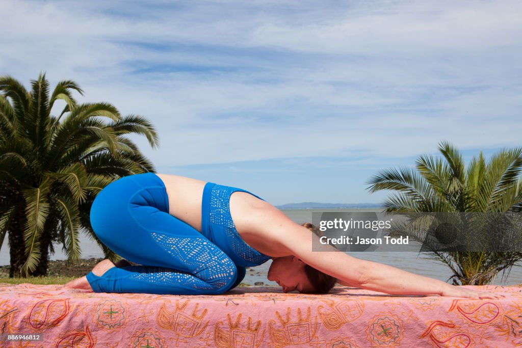 Woman practicing yoga in nature wearing blue yoga outfit