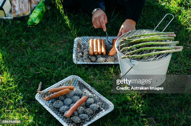 mans hands preparing barbecue on bucket - briketts stock-fotos und bilder