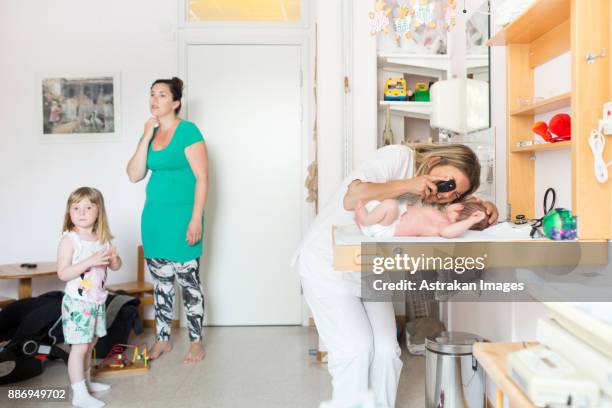 baby (0-1 months) being examined by doctor - 0 1 mes fotografías e imágenes de stock