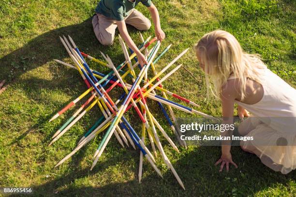boy (4-5) and girl (8-9) playing giant pick up ticks - large garden foto e immagini stock