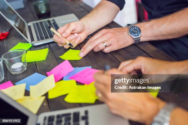 coworkers writing on post-it notes - instrument of time stock pictures, royalty-free photos & images