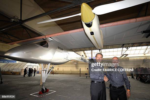 Swiss scientist-adventurer and pilot Bertrand Piccard and Solar Impulse CEO Andre Borschberg pose under the 'Solar Impulse' airplane during an...