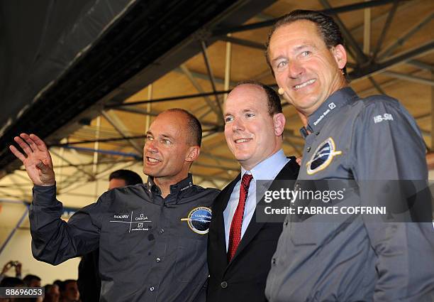 Swiss scientist-adventurer and pilot Bertrand Piccard and Solar Impulse CEO Andre Borschberg pose with Prince Albert II of Monaco as they unveil the...