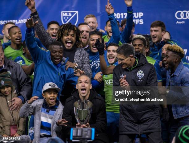 Osvaldo Alonso of the Seattle Sounders hoists the championship trophy as other members of of the Seattle Sounders celebrate after the second leg of...