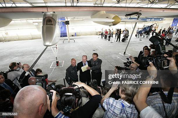 Swiss scientist-adventurer and pilot Bertrand Piccard and Solar Impulse CEO Andre Borschberg pose with Prince Albert II of Monaco after they unveil...