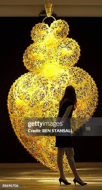 An artwork entitled ''Gold Independent Heart' by artist Joana Vasconcelos is pictured at Christie's auction house, in central London, on June 26,...