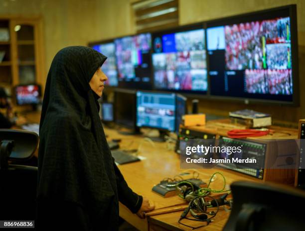 muslim female tv editor working with vision mixer in television broadcast gallery - iraqi woman - fotografias e filmes do acervo