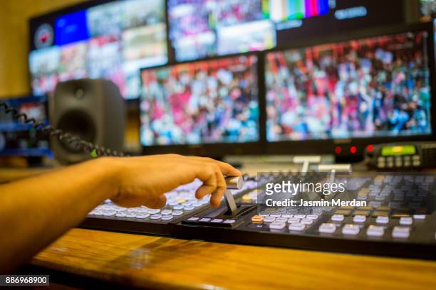 tv editor working with vision mixer in television broadcast gallery - broadcasting stock-fotos und bilder