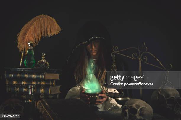 weibliche assistenten am tisch mit magische gegenstände - alchemie stock-fotos und bilder