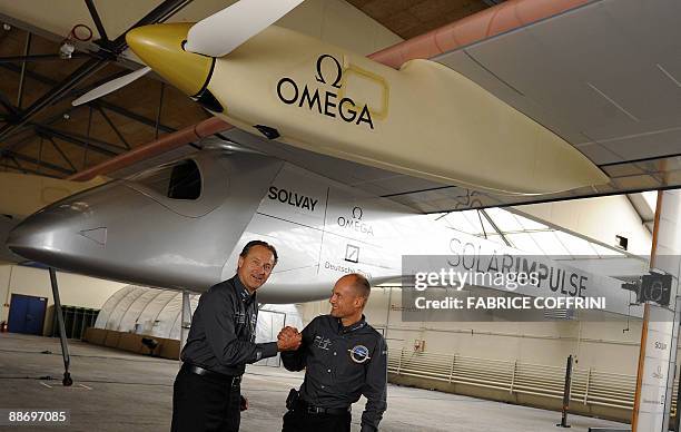 Swiss scientist-adventurer and pilot Bertrand Piccard and Solar Impulse CEO Andre Borschberg pose after they unveil the 'Solar Impulse' airplane...