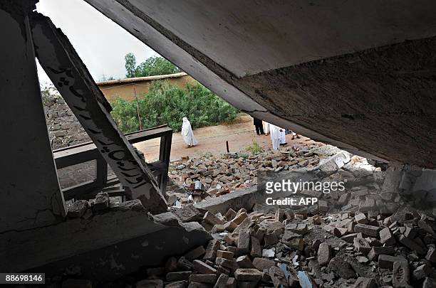 Pakistani woman walks past badly damaged classrooms after militants blew up a girl�s school in Mattni village near Peshawar on June 26, 2009....