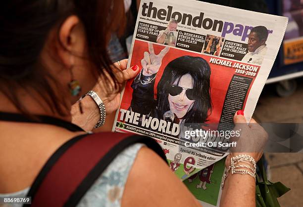 Woman reads a copy of The London Paper informing of the death of singer Michael Jackson in Piccadilly Circus on June 26, 2009 in London, England....