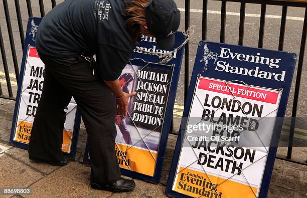 An Evening Standard employee adjusts a poster for the newspaper informing of the death of singer Michael Jackson in Piccadilly Circus on June 26,...