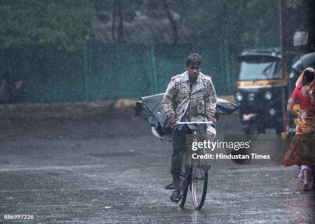 People deals with sudden rain due to side effect of Cyclone Ockhi at Versova, on December 5, 2017 in Mumbai, India. Mumbai and its suburbs received...
