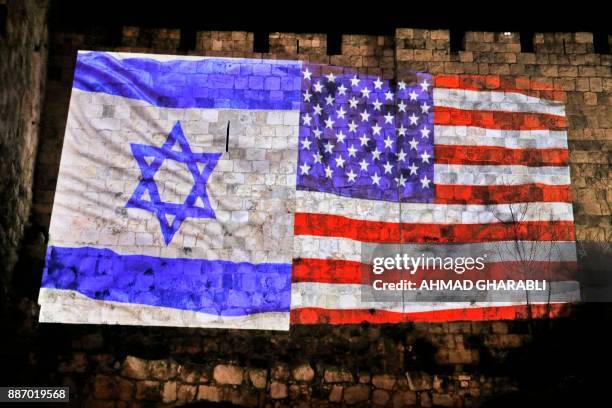 Picture taken on December 6, 2017 shows a giant US flag screened alongside Israel's national flag by the Jerusalem municipality on the walls of the...