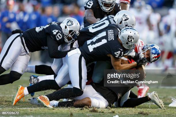 Kalif Raymond of the New York Giants is tackled by Marquel Lee, Erik Harris, Jamize Olawale and Obi Melifonwu of the Oakland Raiders at...