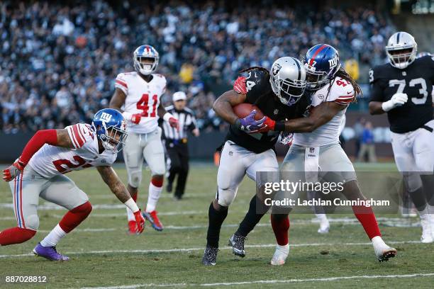 Marshawn Lynch of the Oakland Raiders is tackled by Kelvin Sheppard of the New York Giants at Oakland-Alameda County Coliseum on December 3, 2017 in...