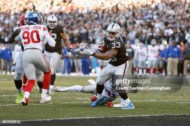 DeAndré Washington of the Oakland Raiders runs by Landon Collins of the New York Giants for a touchdown at Oakland-Alameda County Coliseum on...