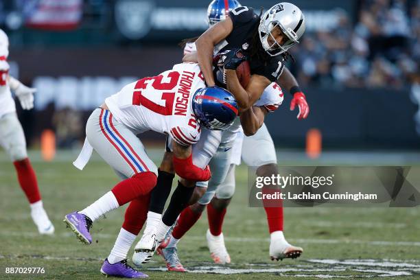 Seth Roberts of the Oakland Raiders is tackled by Darian Thompson and Ross Cockrell of the New York Giants at Oakland-Alameda County Coliseum on...