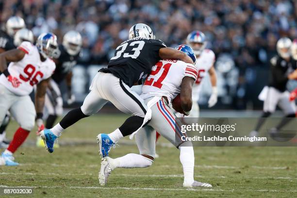 Landon Collins of the New York Giants is tackled by DeAndré Washington of the Oakland Raiders after Collins recovered a fumble at Oakland-Alameda...