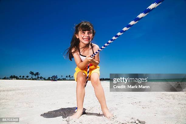 young girl playing tug-of-war. - captiva island stock-fotos und bilder